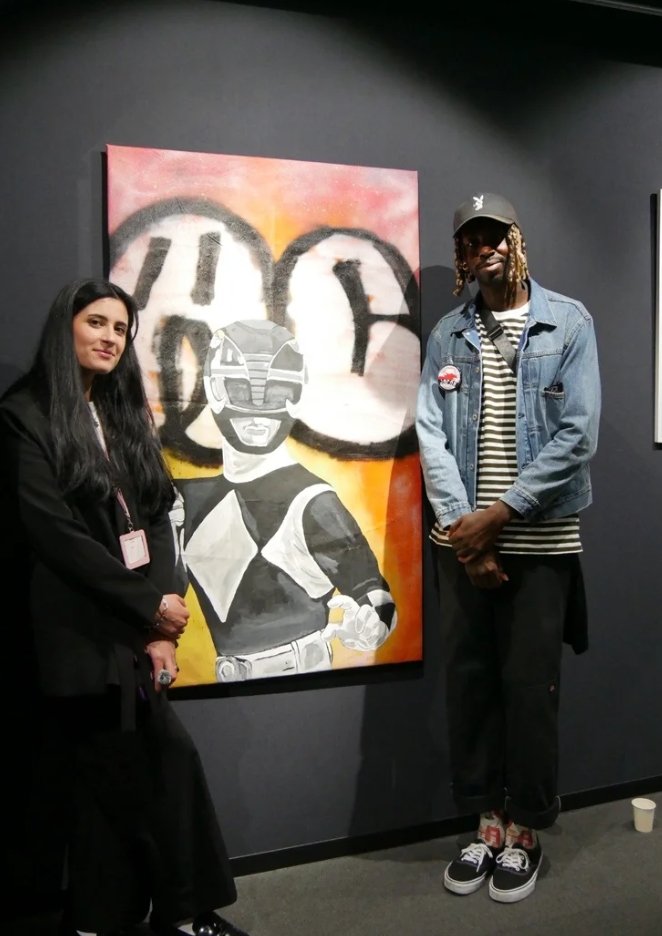 Two guests beside a colourful gallery painting