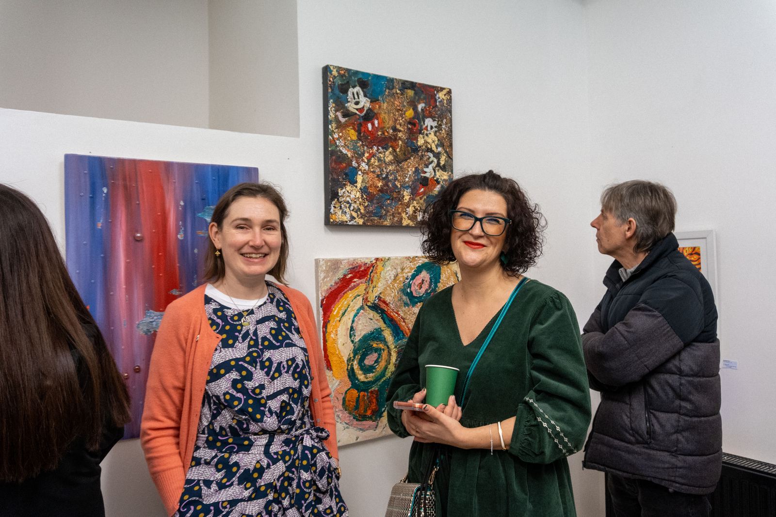 Two guests smiling in a gallery