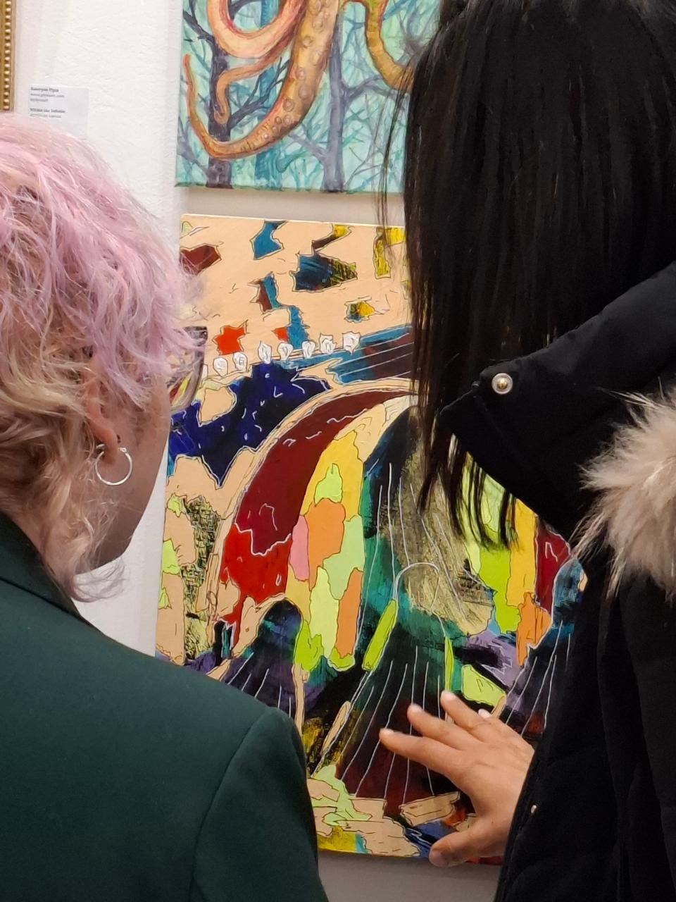 Visitors viewing a colourful work